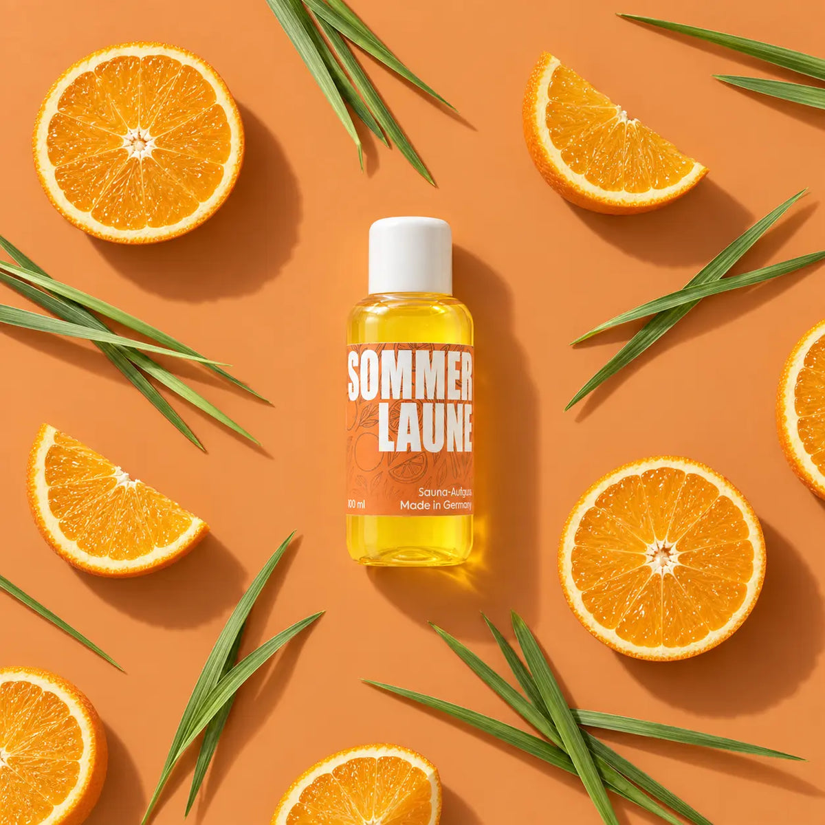 kaisa SOMMERLAUNE Saunaaufguss, 100-ml-Flasche mit Orangenscheiben und grünen Halmen auf orangefarbenem Hintergrund