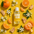 kaisa HAMAMGLANZ Saunaaufguss, 100-ml-Flasche mit Orangen, weißen Blüten und Holzstücken auf gelbem Hintergrund